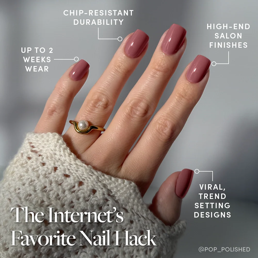 A hand with glamnetic’s Mauve On press-on nails, featuring a trendy short squoval shape and chip-resistant, high-end finish, wears a gold ring with a pearl and rests on a textured knit sleeve. Enjoy up to 2 weeks of flawless wear.