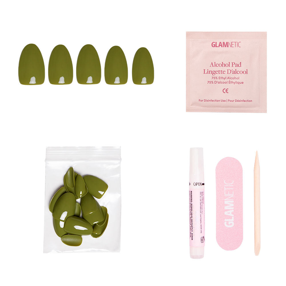 The glamnetic Moss Green set includes olive press-on nails, alcohol pad, extra nails, pink nail file, wooden cuticle stick, and glue—all arranged on a white background for the perfect fall look.