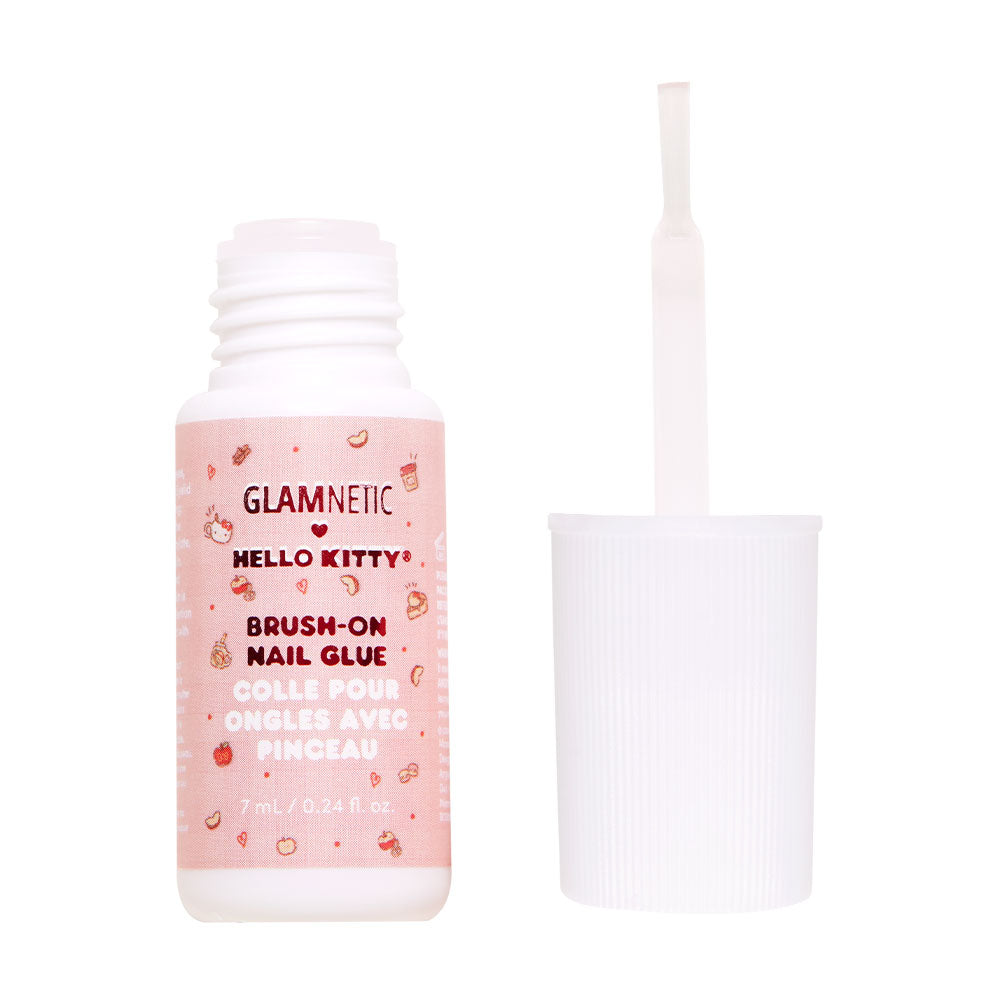 An open bottle of glamnetic Hello Kitty™ Brush-On Nail Glue with a white cap and brush, showcasing a pink label with cute icons and bilingual text—ideal for easy at-home manicures.