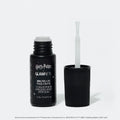 A black bottle of glamnetic Harry Potter™ x Glamnetic Brush-On Nail Glue stands upright with the cap off, showing its brush applicator—ideal for press-on nails. The label displays both English and French text.