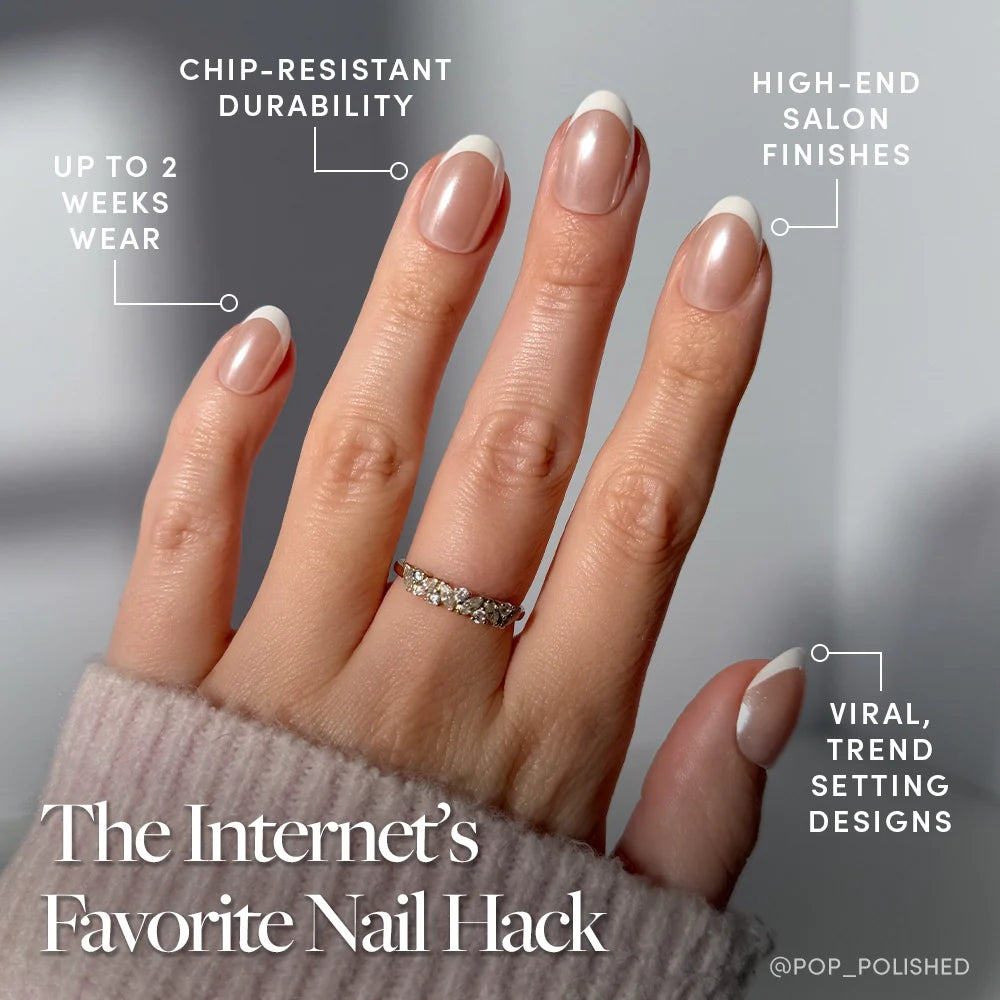 A hand with a French Tip Manicure and silver ring showcases glamnetic’s Pearlfect press-on nails, known for their chip-resistant durability, salon-quality finishes, viral trendy designs, and up to two weeks of wear.