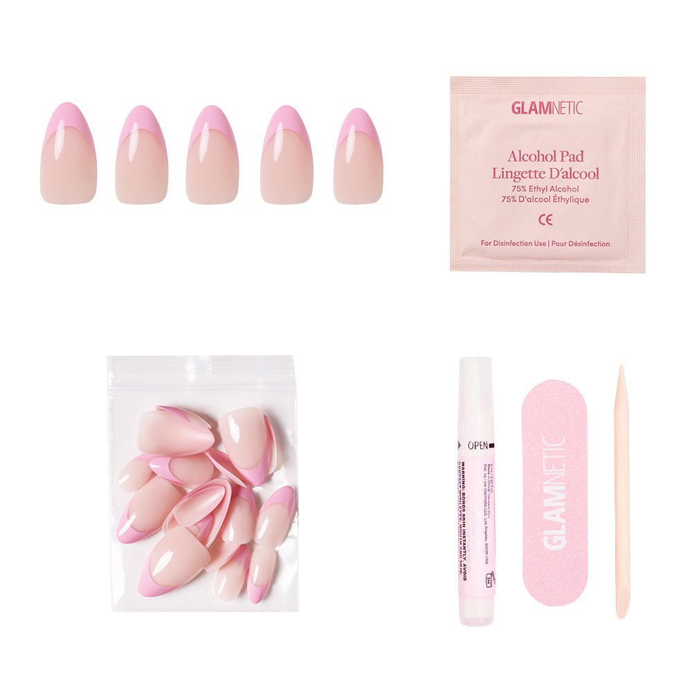 The glamnetic Pink Macaron Nail Set includes almond base pink French tip nails, extra nails in a small bag, nail glue, an alcohol pad, a pink file, and a wooden cuticle stick, all displayed on a white background.