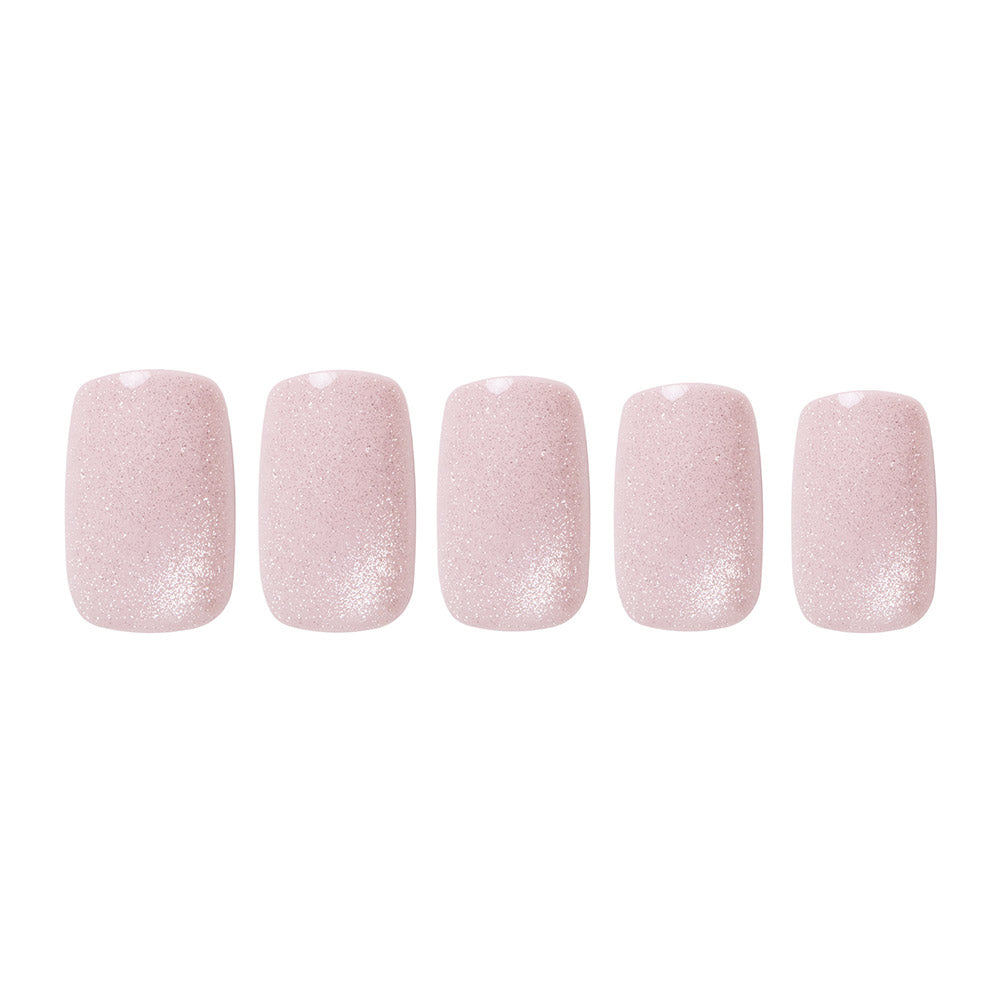 Glamnetic’s Pinky Promise: five reusable nails with a soft pink blush velvet finish and subtle glitter accents, arranged in a row on a white background.