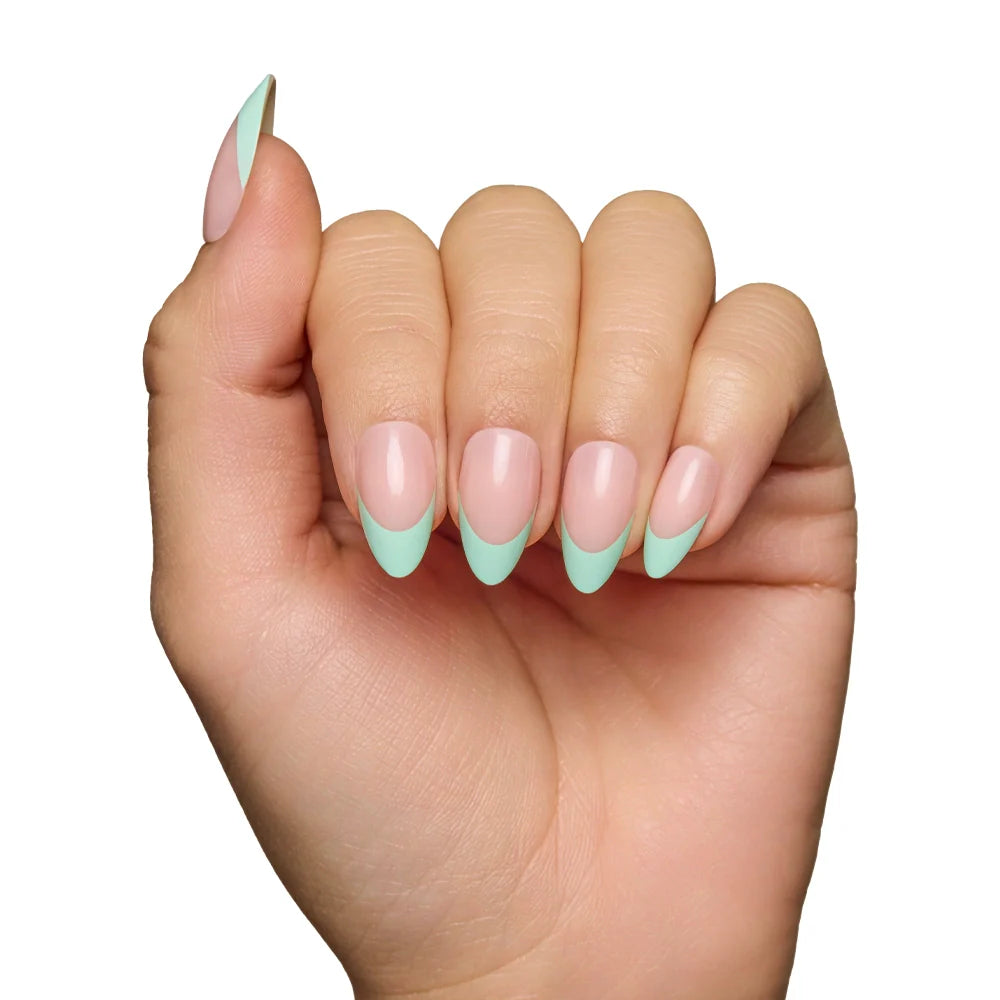 A hand with almond-shaped glamnetic Pistachio Crème press-on nails, featuring pale pink bases and light mint green French tips for a modern, salon-quality look, is shown against a white background.
