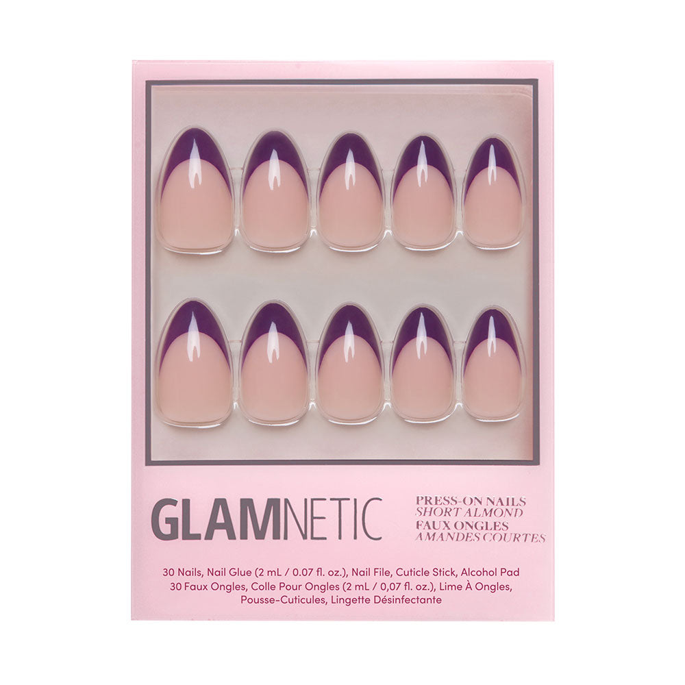 The glamnetic Plum press-on nails set features short almond-shaped nude nails with dark purple French tips. The box includes nail glue, a nail file, a cuticle stick, and an alcohol pad.
