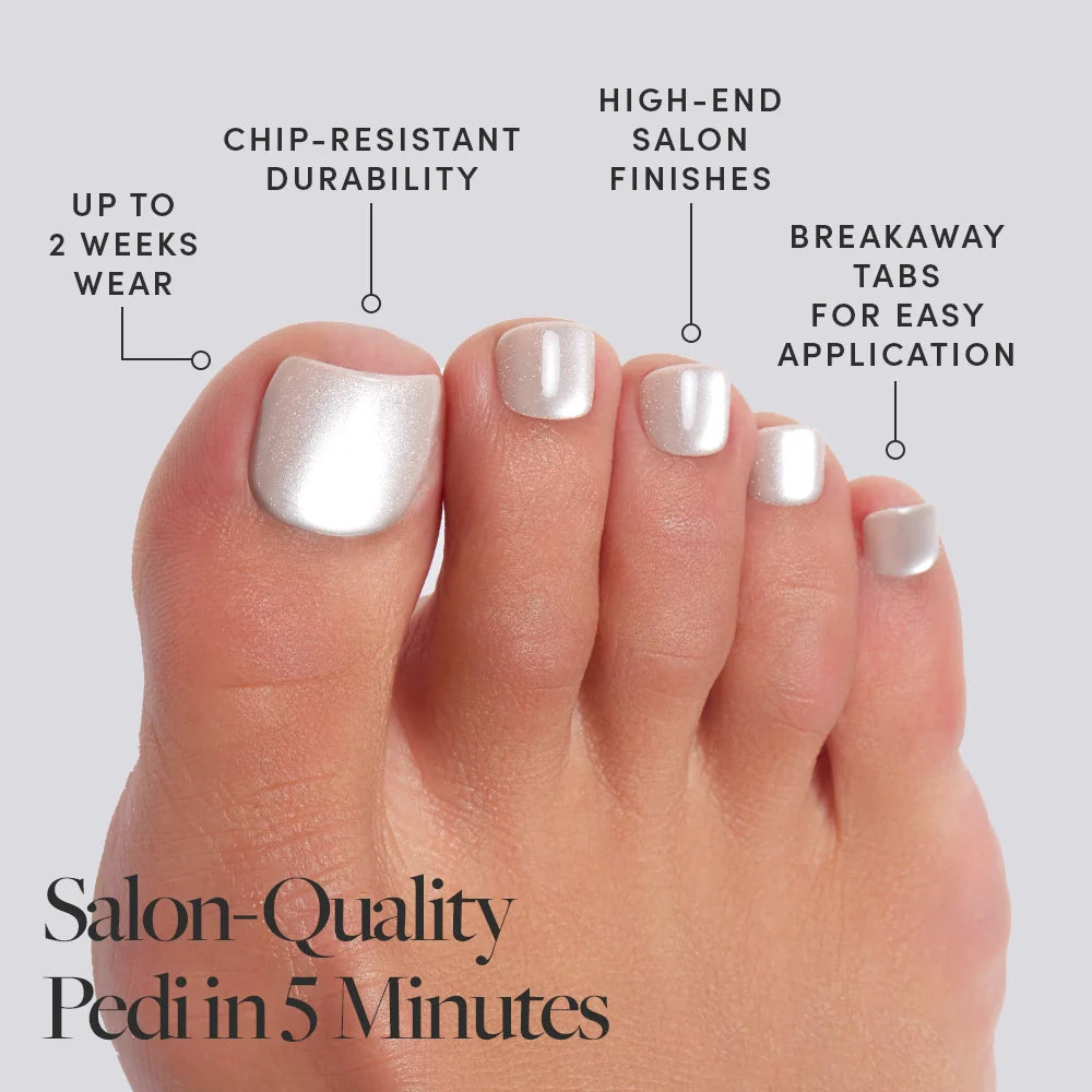 A foot wearing frosted, pearlescent white Glamnetic press-on toenails with product features called out, including salon finish and 2-week wear.
