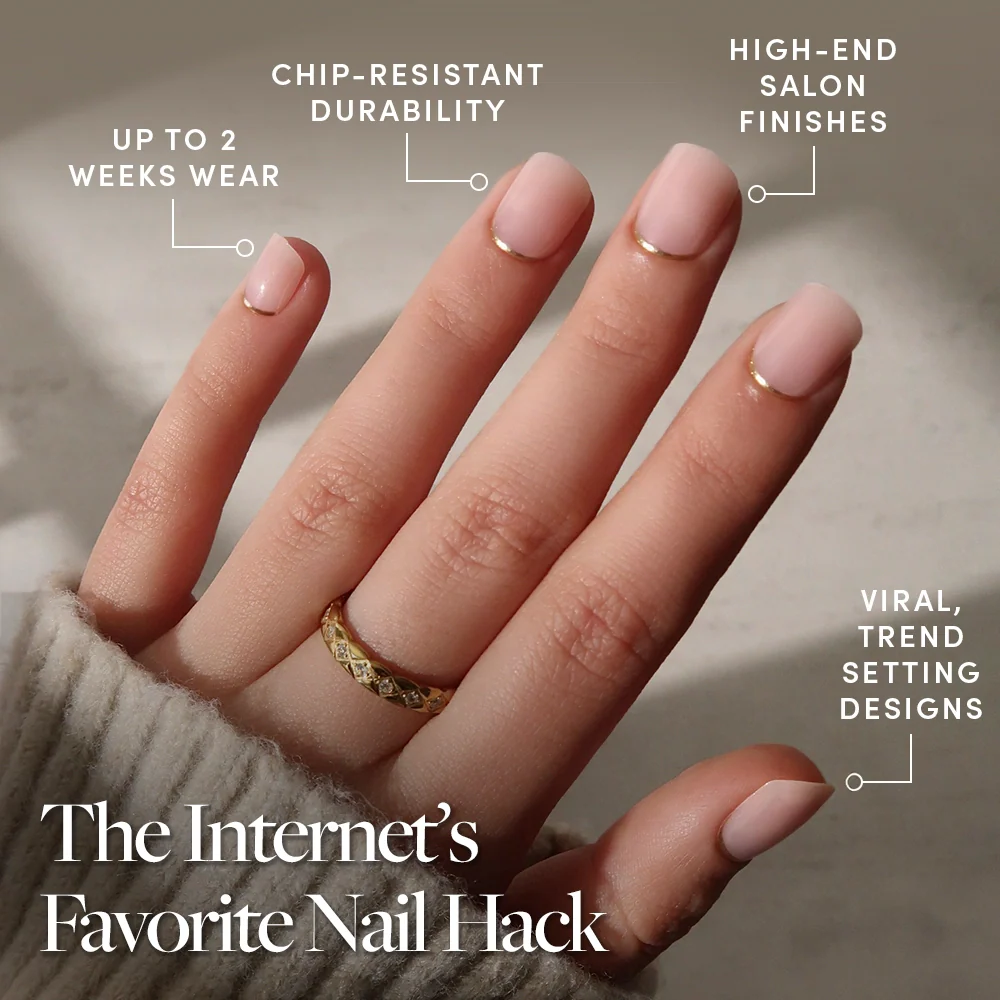 A hand with glamnetic Quiet Luxury press-on nails shows off pale pink color, gold accents, a gold French tip, and a chic ring. Enjoy chip-resistant durability, up to 2 weeks’ wear, salon-quality finish, and viral trendy design.