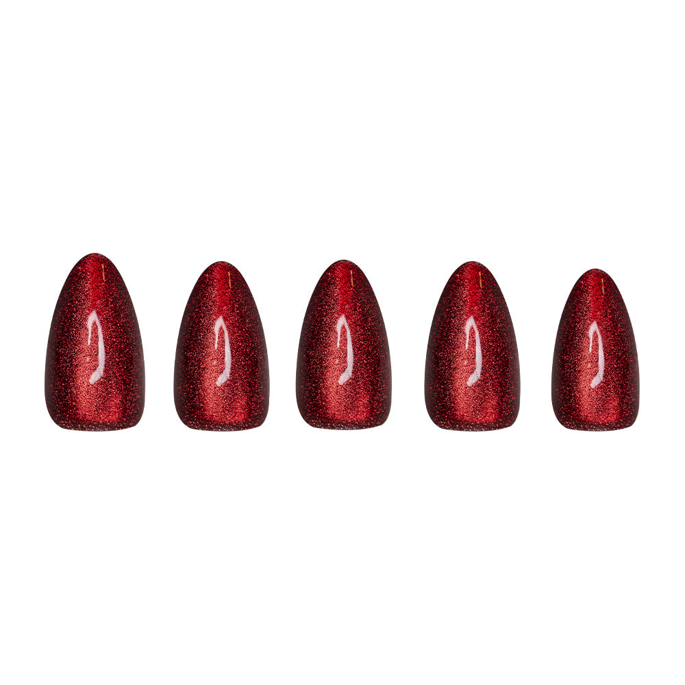 Five short almond artificial nails from glamnetic’s Ruby Slipper set, featuring a glossy, glittery red finish, are displayed in a row on a white background.