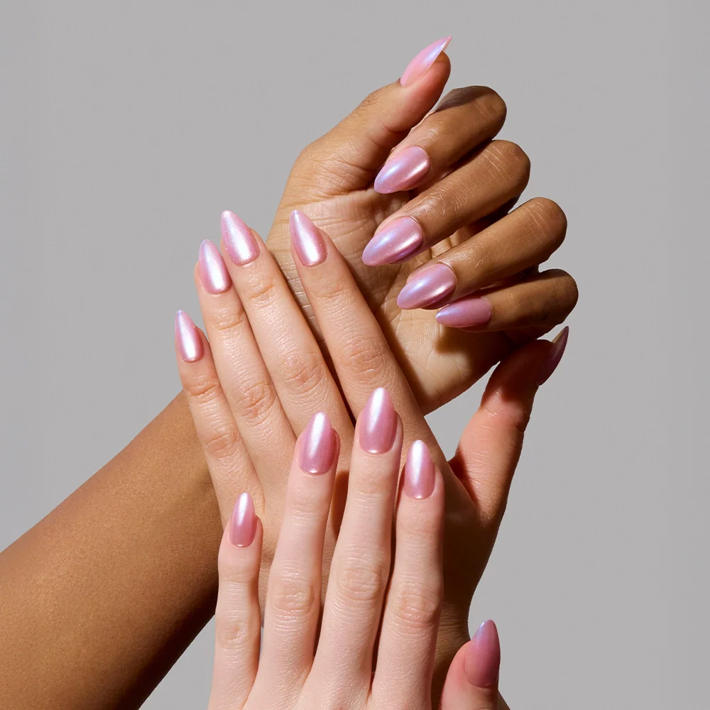 Three hands with long, almond-shaped nails painted in glamnetic’s Seaspell shimmer polish are displayed against a plain gray background, highlighting the glossy and elegant manicure.