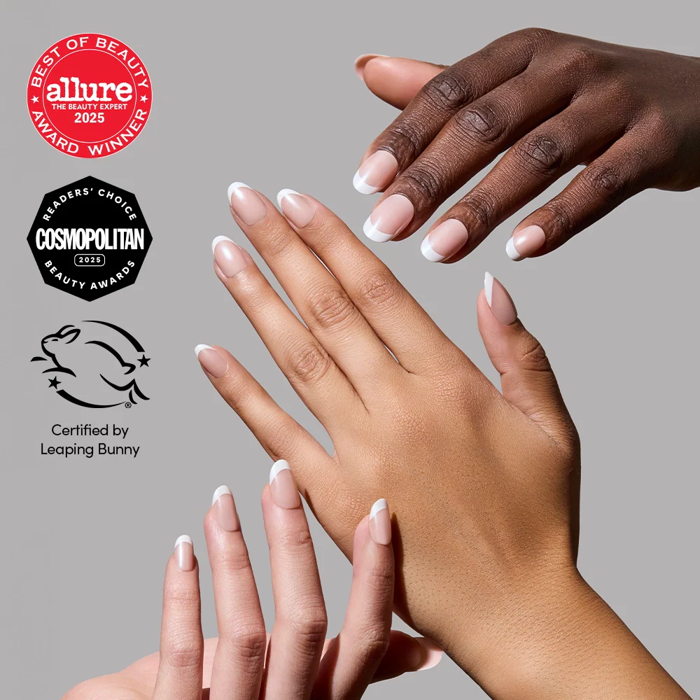 Three hands with different skin tones showcase glamnetic’s She's a Pearl French Tip press-on nails with white tips. Allure and Cosmopolitan beauty awards and Leaping Bunny cruelty-free certification appear on a gray background.