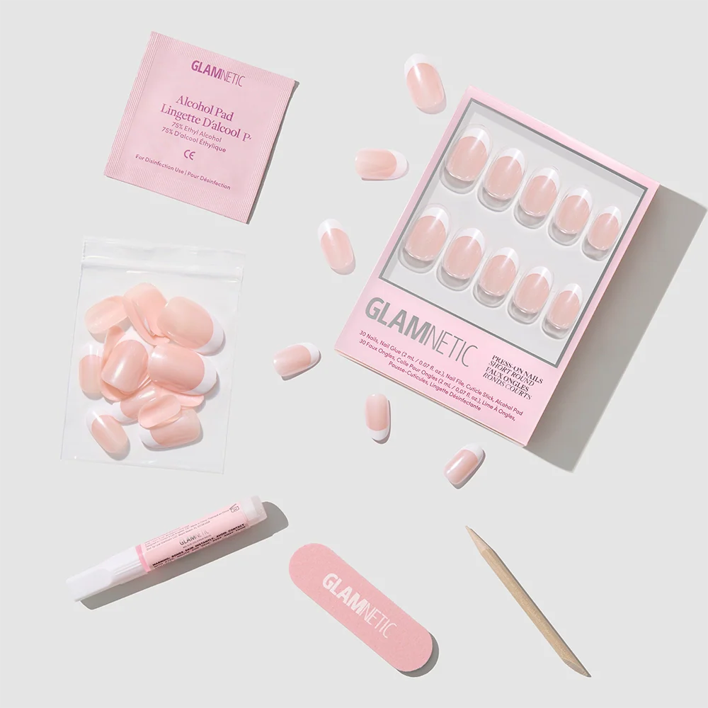 The glamnetic "She's a Pearl" set features pink press-on nails with a pearlescent glazed finish, plus alcohol pad, nail glue, adhesive tabs, nail file, and cuticle stick—all displayed on a light gray background.
