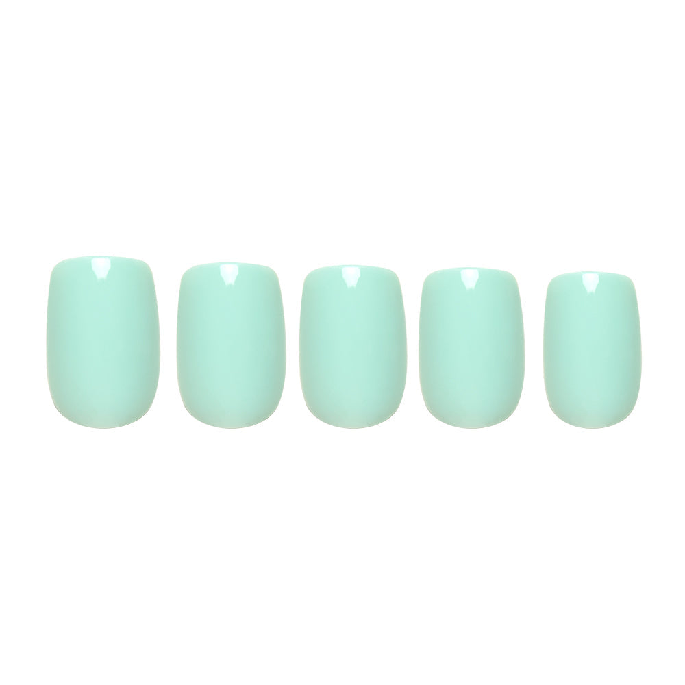 Five short squoval press-on nails in a glossy soft teal shade from glamnetic, arranged on a white background. The Soft Teal set offers an elegant, effortless look.
