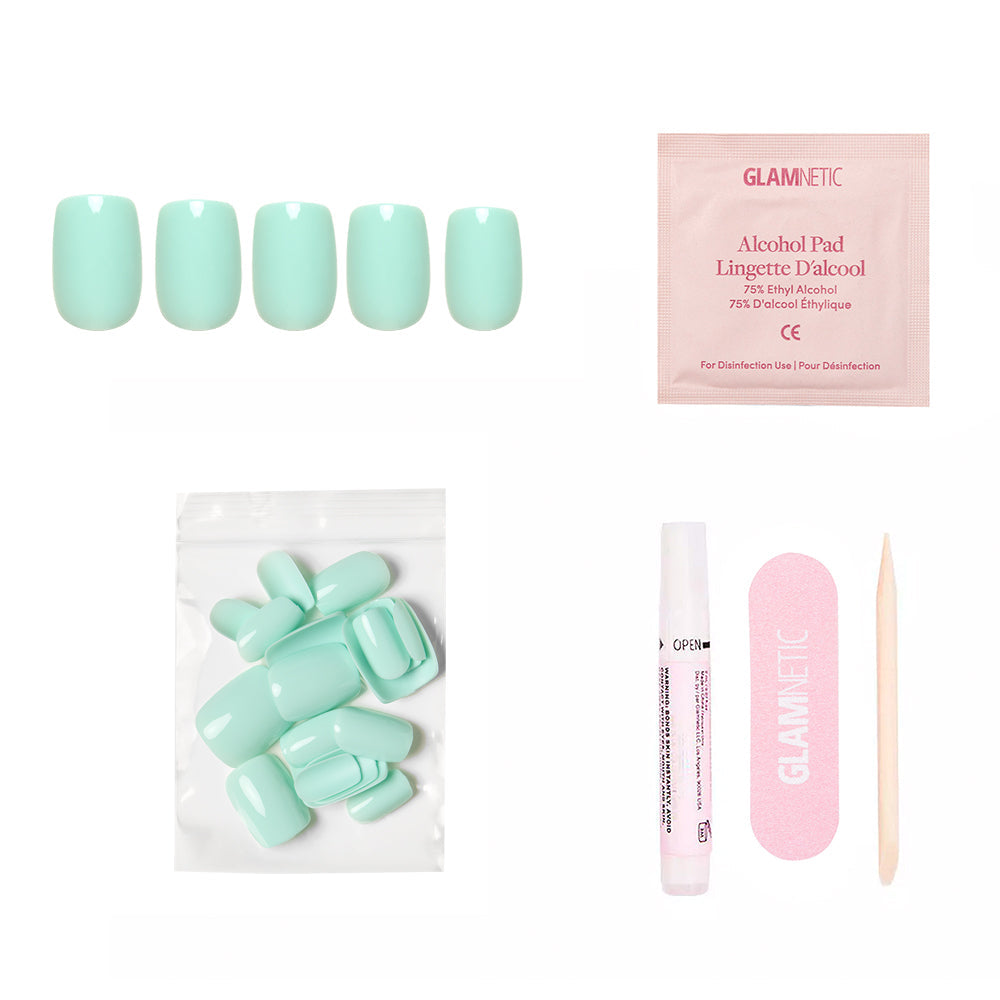 The glamnetic Soft Teal Nail Set includes short squoval press-on nails, an alcohol pad, adhesive tube, pink nail file, wooden cuticle stick, and a pouch of extra nails—all displayed on a white background.