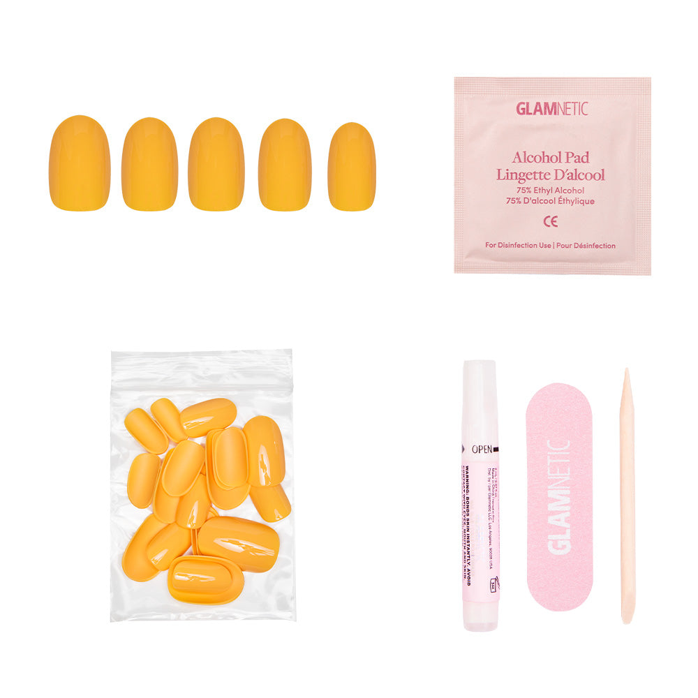 The glamnetic Sunset Orange set includes vibrant yellow press-on nails, an alcohol pad, extra nails in a bag, nail glue, a pink file, and a wooden cuticle stick—all shown on a white background. Perfect for summer style.