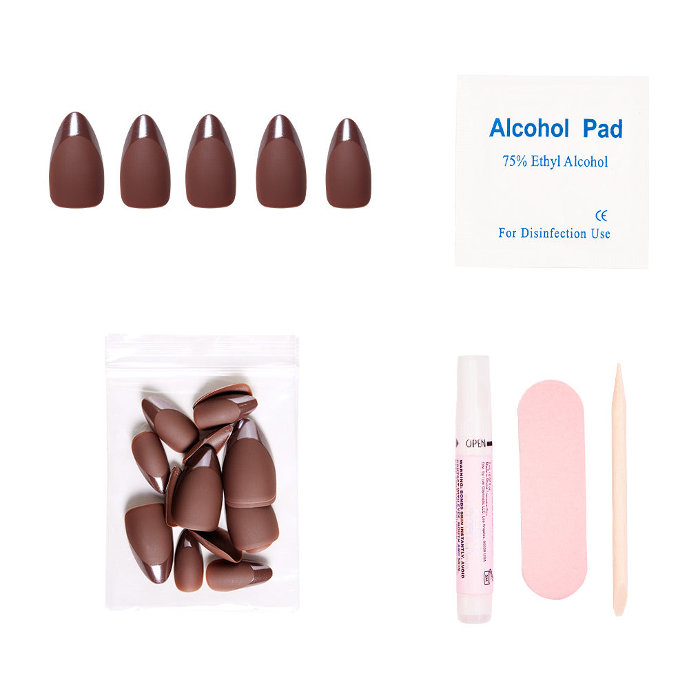 The glamnetic Terra press-on nail kit includes matte earthy-brown nails, extra nails (in a plastic bag), an alcohol pad, glue tube, pink nail file, and wooden cuticle stick—all arranged on a white background.