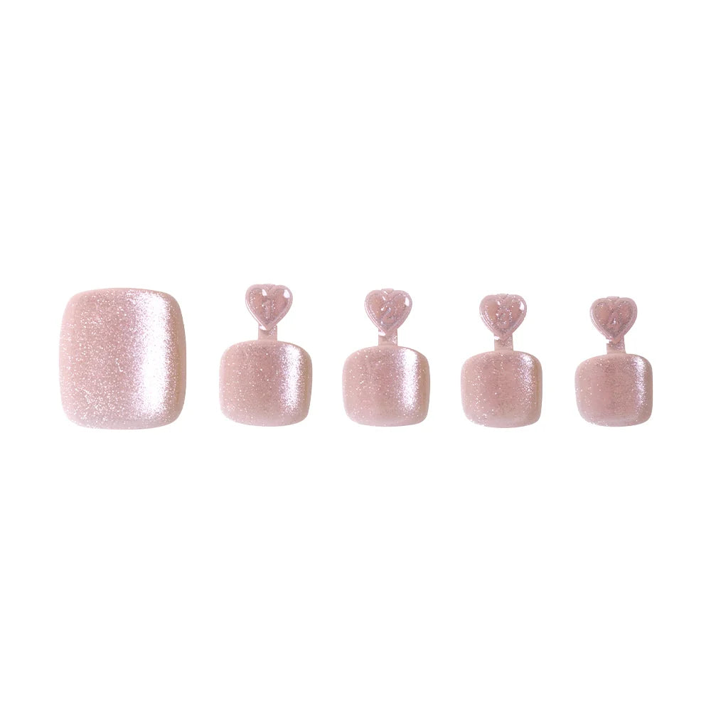 Shimmering champagne glitter press-on toenails in five sizes, each with heart-shaped tabs for application.