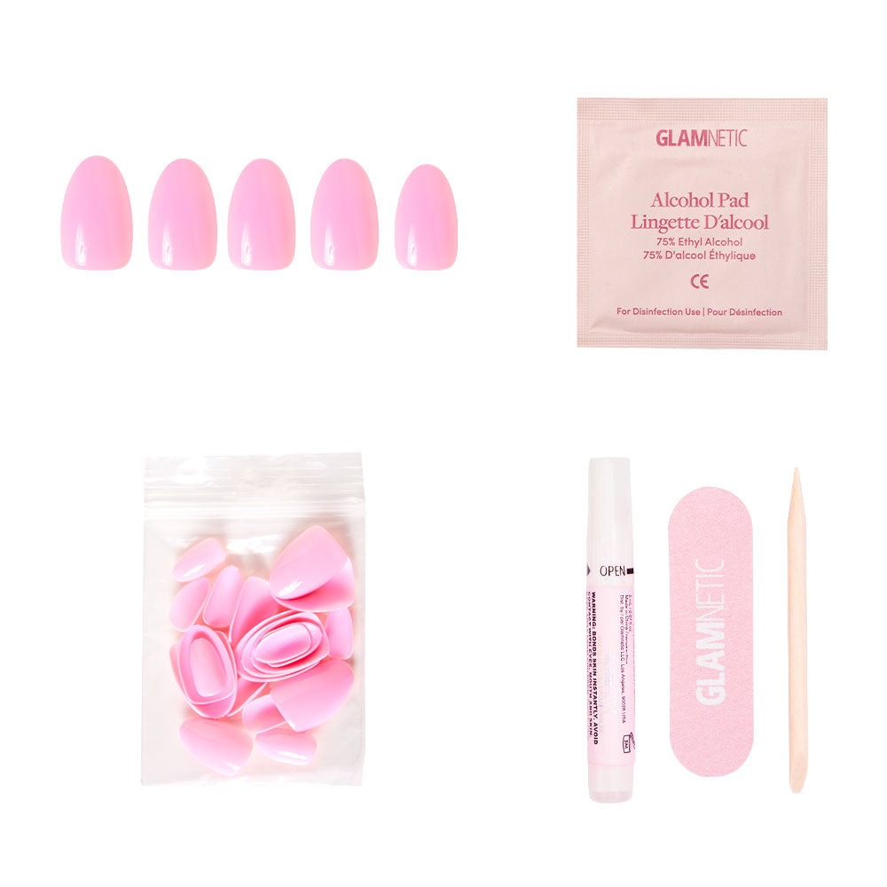 The glamnetic Think Pink set includes baby pink press-on nails, extra nails, nail glue, an alcohol pad, a matching nail file, and a wooden cuticle stick—all arranged on a white background.