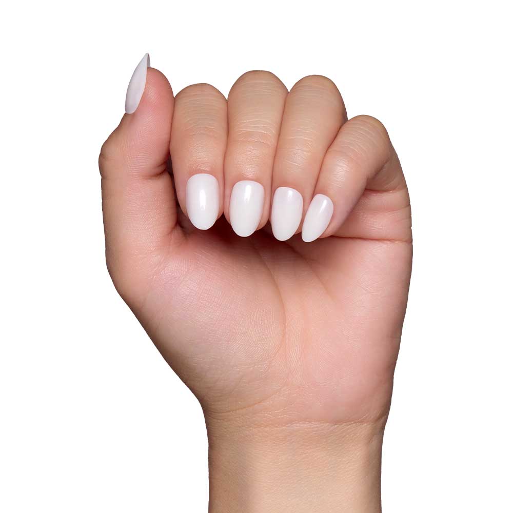 A hand with short oval nails, featuring a glossy finish and painted with the White Swan nail set by glamnetic, is displayed against a plain white background.