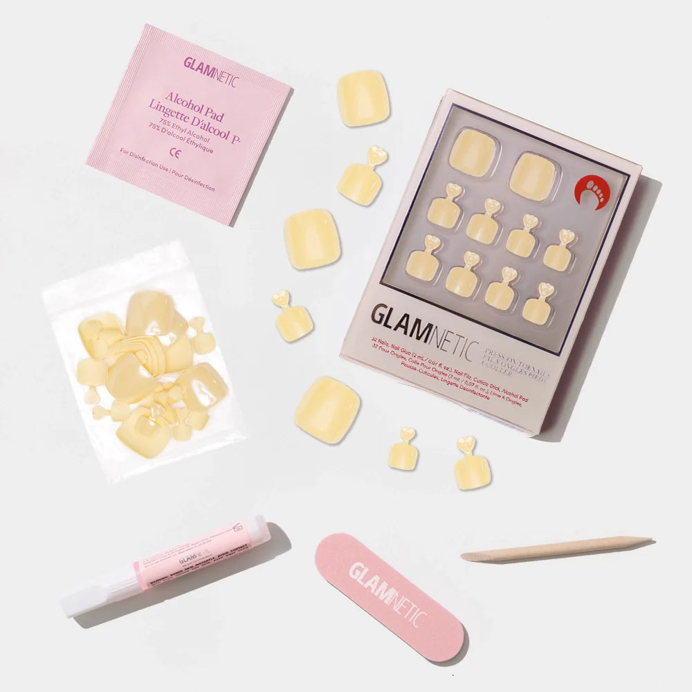 A flat-lay of the Glamnetic pastel yellow press-on toenail kit with a smooth, glossy finish and full prep set.